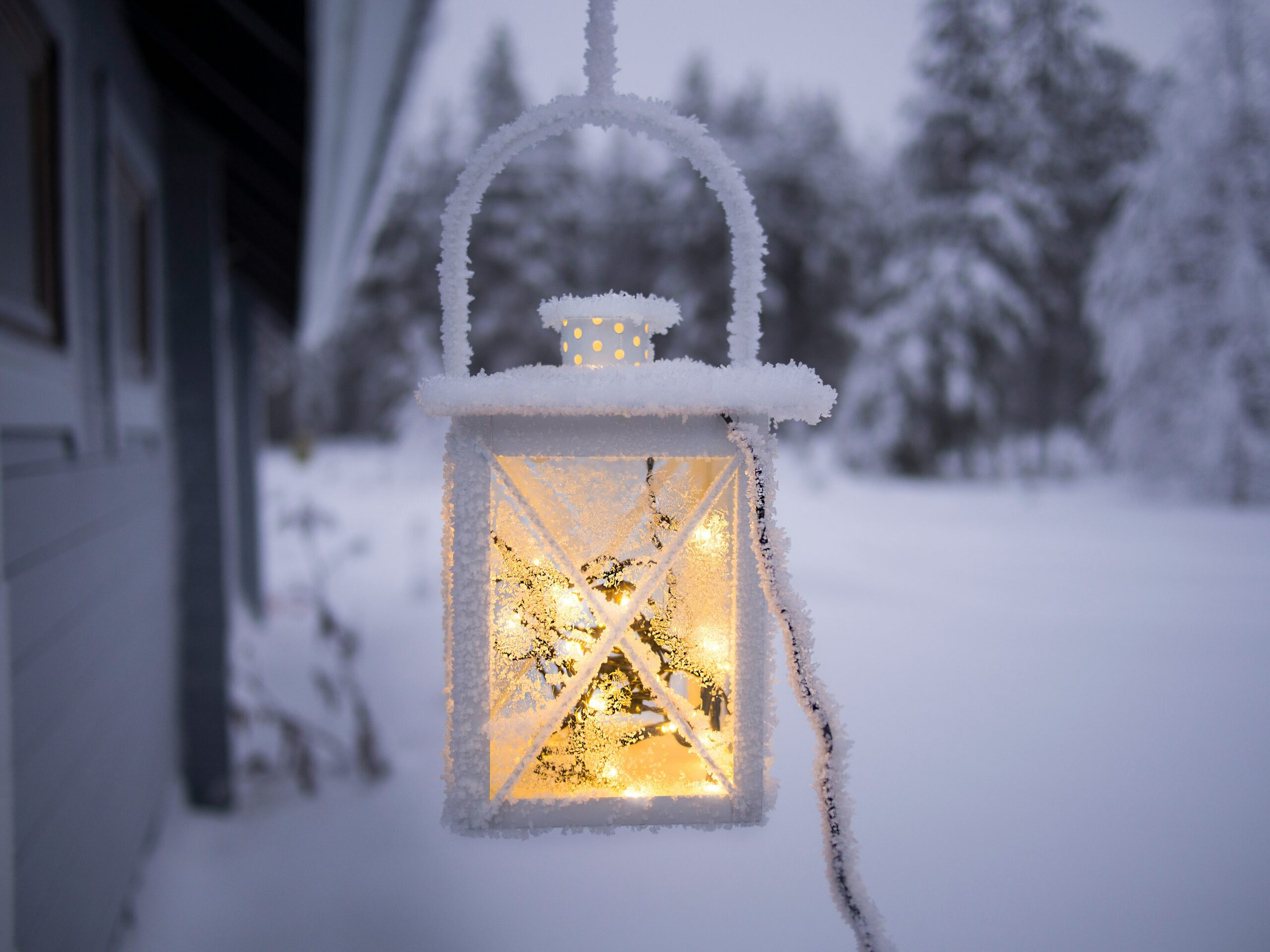 A beautiful lantern lit by fairy lights glow in a wintery dusk