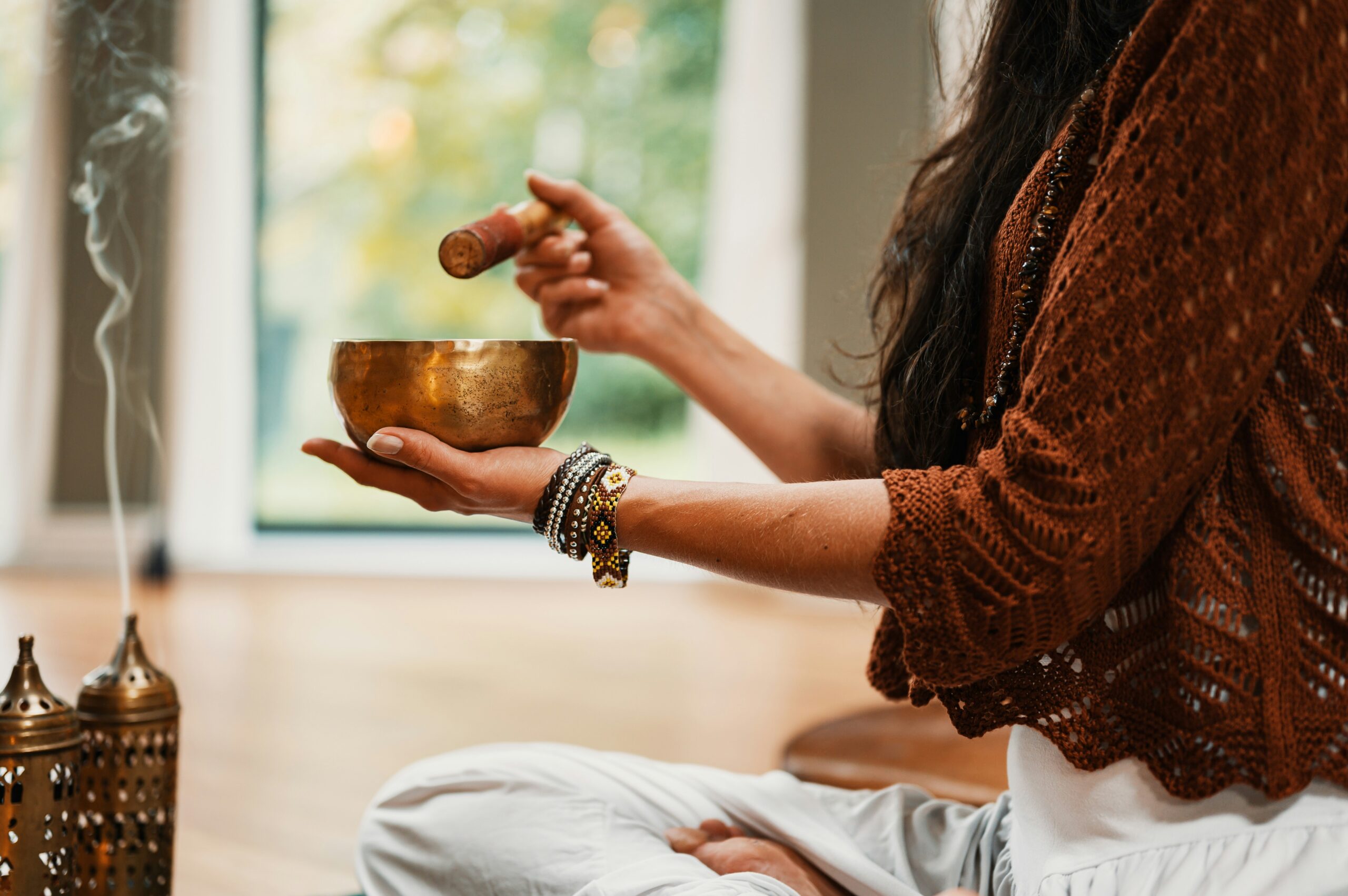 a person burns incense in preparation for a fall equinox meditation session 