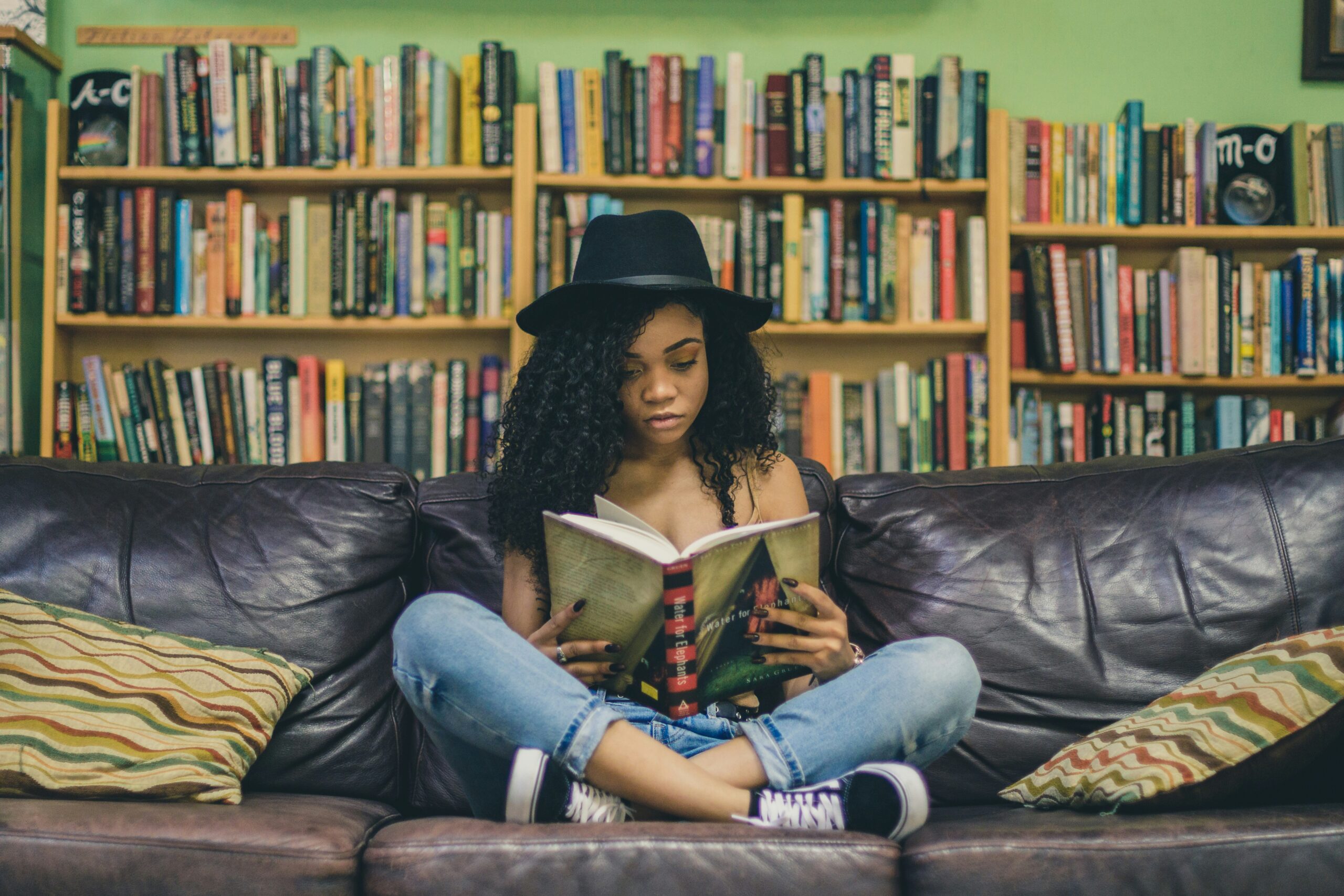 A young woman sits reading a book.